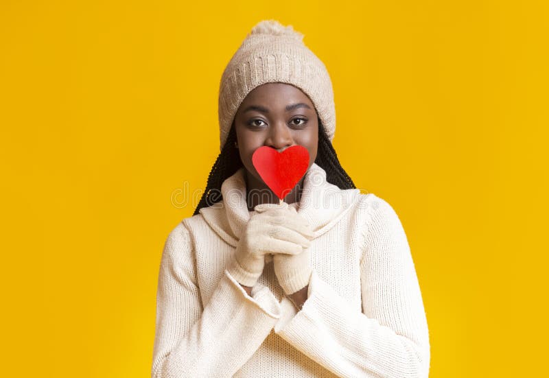 Mysterisk afro vinterflicka som täcker sina läppar med valentinkort royaltyfri fotografi Mysterisk afro vinterflicka som täcker sina läppar med valentinkort royaltyfri fotografi