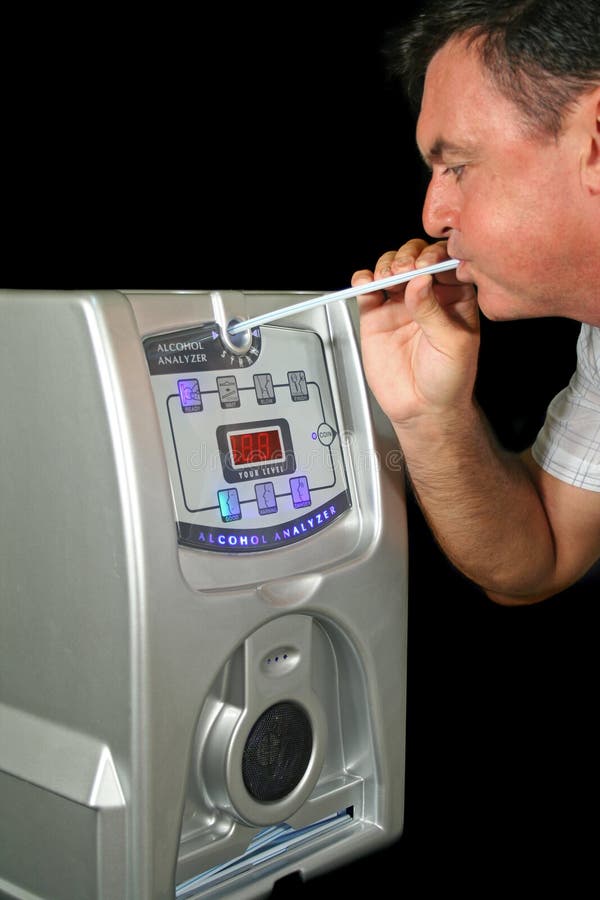 Man tests his alcohol level with a breath test machine. Man tests his alcohol level with a breath test machine.