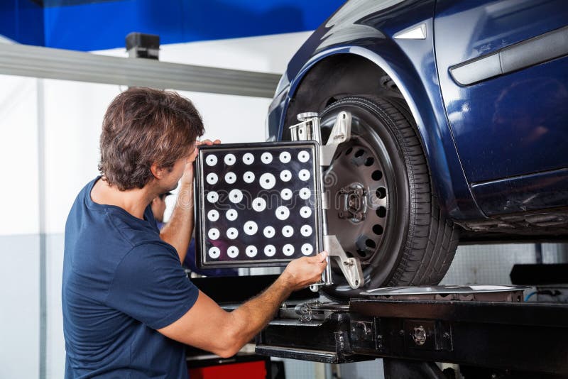 Máquina de Adjusting Wheel Alignment do mecânico foto de stock royalty free Máquina de Adjusting Wheel Alignment do mecânico foto de stock royalty free