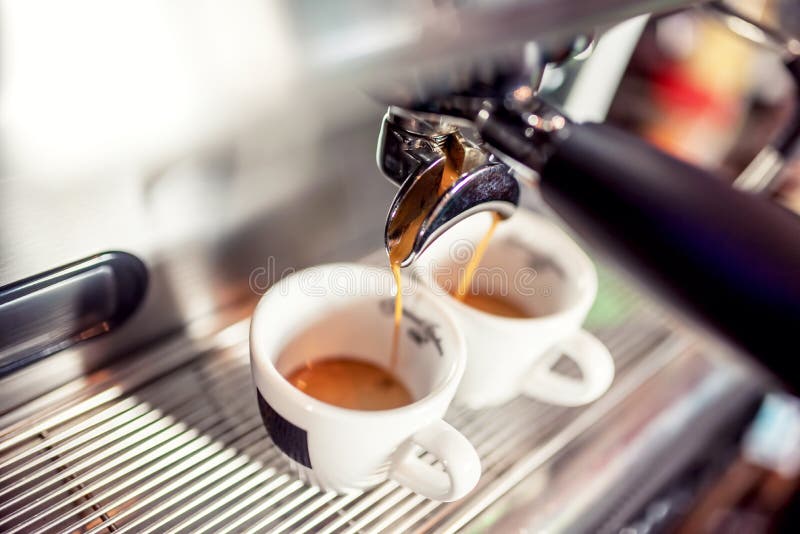 Máquina de café express que vierte el café fresco en las tazas en el restaurante Máquina automática del café que hace el café foto de archivo libre de regalías Máquina de café express que vierte el café fresco en las tazas en el restaurante Máquina automática del café que hace el café foto de archivo libre de regalías