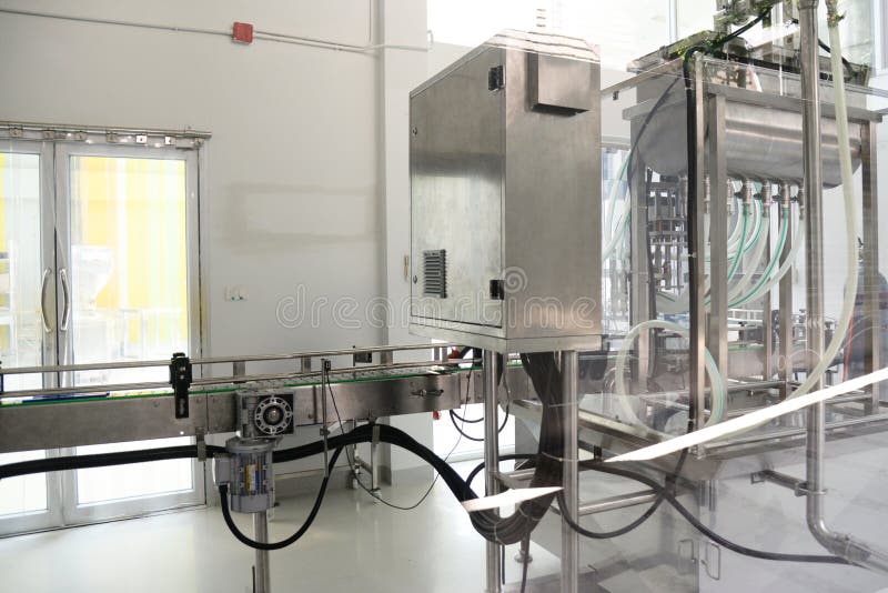 Máquina de enchimento automática de derramamento pneumática da garrafa industrial fotografia de stock Máquina de enchimento automática de derramamento pneumática da garrafa industrial fotografia de stock
