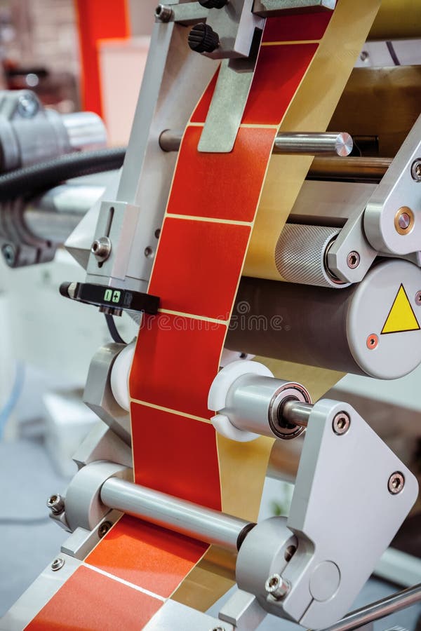 Automatic labeling machine. The labeled tape is located between the feed rollers. Automatic labeling machine. The labeled tape is located between the feed rollers.