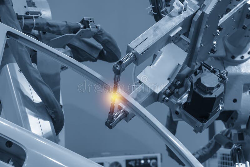 A máquina robótico de solda que solda as peças automotivos imagem de stock royalty free A máquina robótico de solda que solda as peças automotivos imagem de stock royalty free