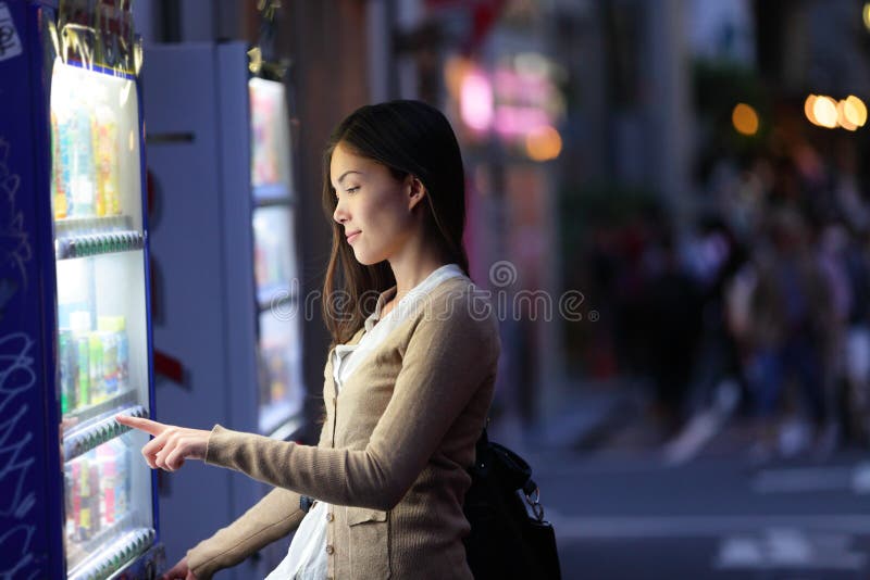 Máquinas de venda automática de Japão - bebidas da compra da mulher do Tóquio imagem de stock Máquinas de venda automática de Japão - bebidas da compra da mulher do Tóquio imagem de stock