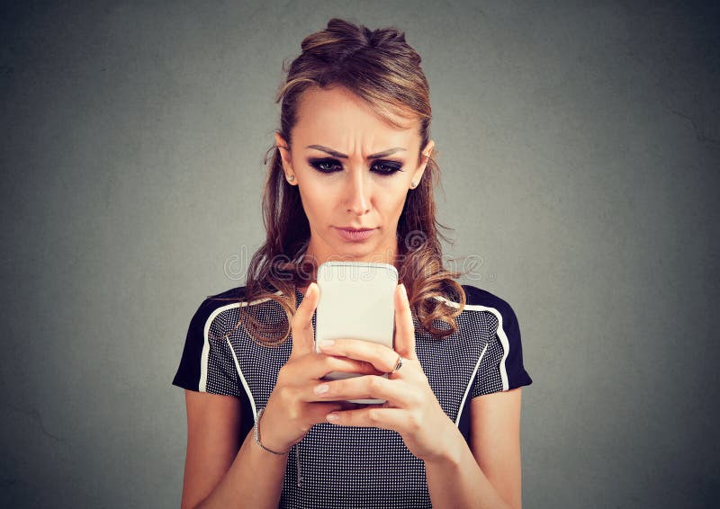 Más notícias preocupadas sérias da leitura da mulher no telefone celular fotografia de stock Más notícias preocupadas sérias da leitura da mulher no telefone celular fotografia de stock