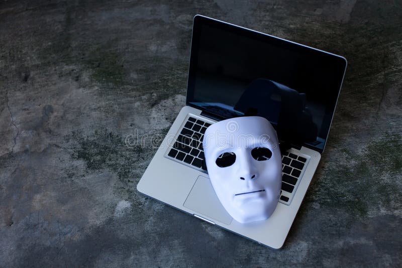 Máscara anónima para ocultar la identidad en el ordenador portátil del ordenador - concepto criminal y cibernético de Internet de