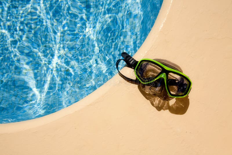 Green scuba mask at the poolside. Green scuba mask at the poolside