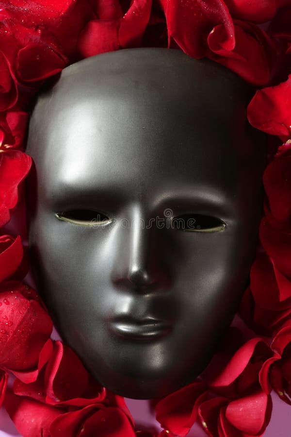Máscara negra del carnaval con los pétalos color de rosa rojos