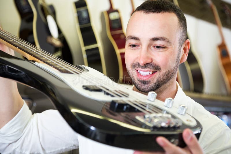 Mâle achetant la nouvelle guitare images libres de droits Mâle achetant la nouvelle guitare images libres de droits