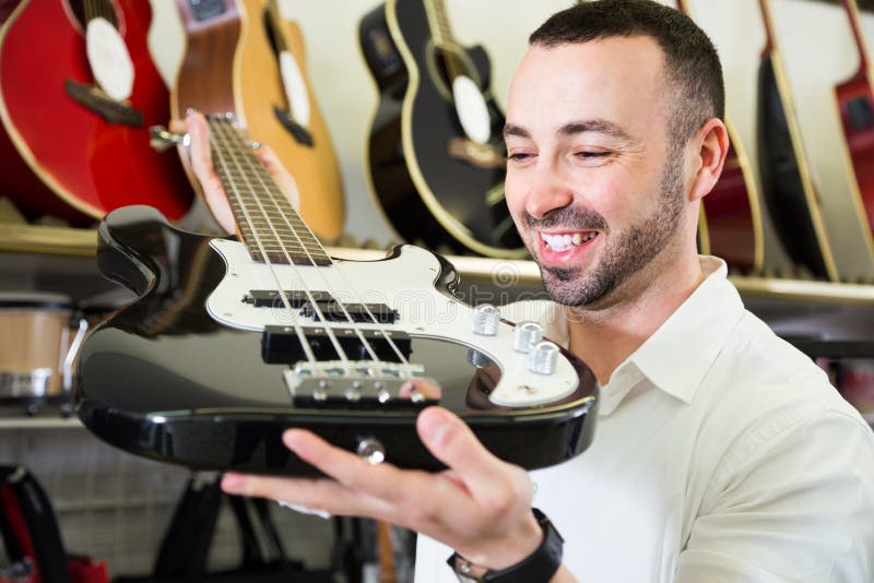 Mâle achetant la nouvelle guitare photos libres de droits Mâle achetant la nouvelle guitare photos libres de droits