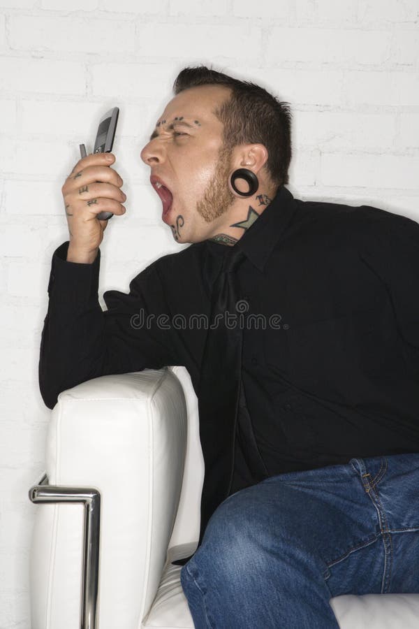 Mâle adulte hurlant dans le téléphone image libre de droits Mâle adulte hurlant dans le téléphone image libre de droits
