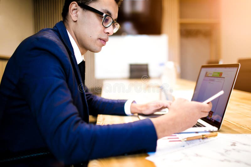 Mâle en texte de dactylographie d'employeur réussi de costume sur le téléphone portable pendant l'utilisation du carnet images libres de droits Mâle en texte de dactylographie d'employeur réussi de costume sur le téléphone portable pendant l'utilisation du carnet images libres de droits