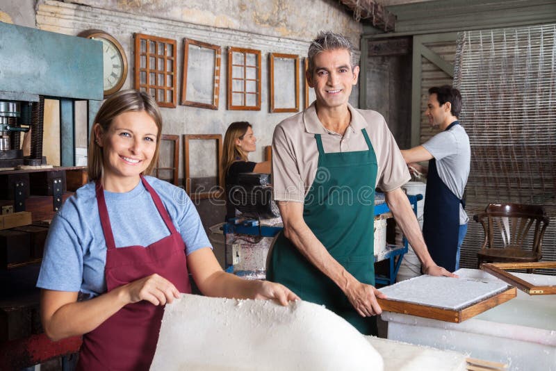 Mâle et main-d'œuvre féminine faisant des papiers dans l'usine photographie stock libre de droits Mâle et main-d'œuvre féminine faisant des papiers dans l'usine photographie stock libre de droits