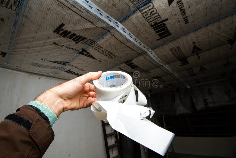 Mâle main tenant le nouvel adhésif à haute performance de knauf pour les chevauchements de collage de photo stock