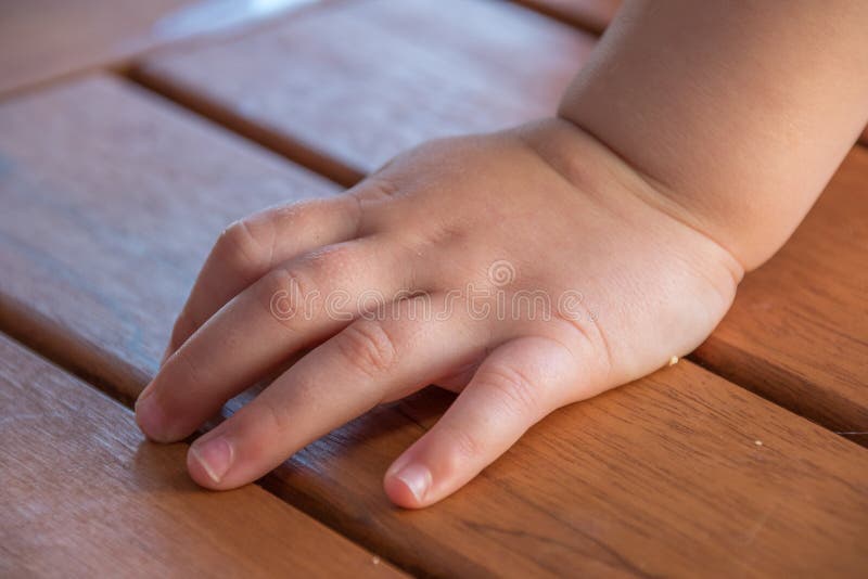Mâna de copil izolată pe suprafața de masă royalty free stock image