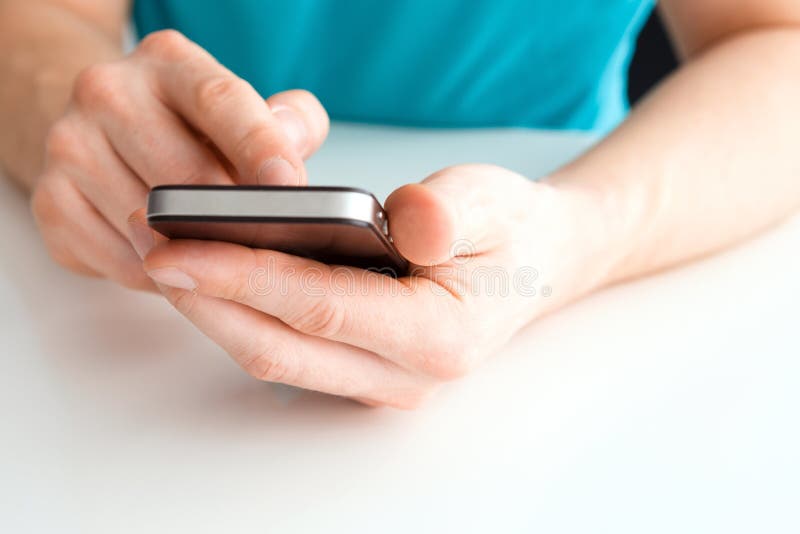 Mâna masculină care ține un telefon mobil și scrie royalty free stock images