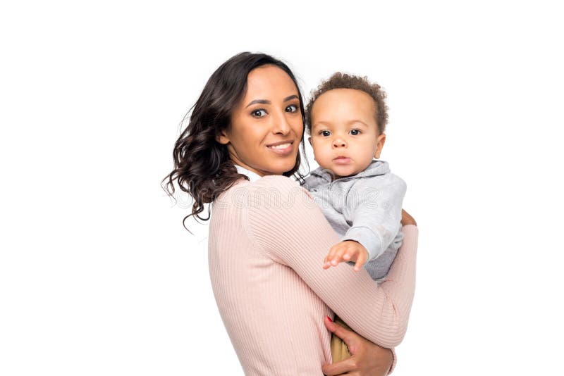 mãe afro-americano feliz que leva a criança pequena adorável e que olha a câmera imagem de stock mãe afro-americano feliz que leva a criança pequena adorável e que olha a câmera imagem de stock