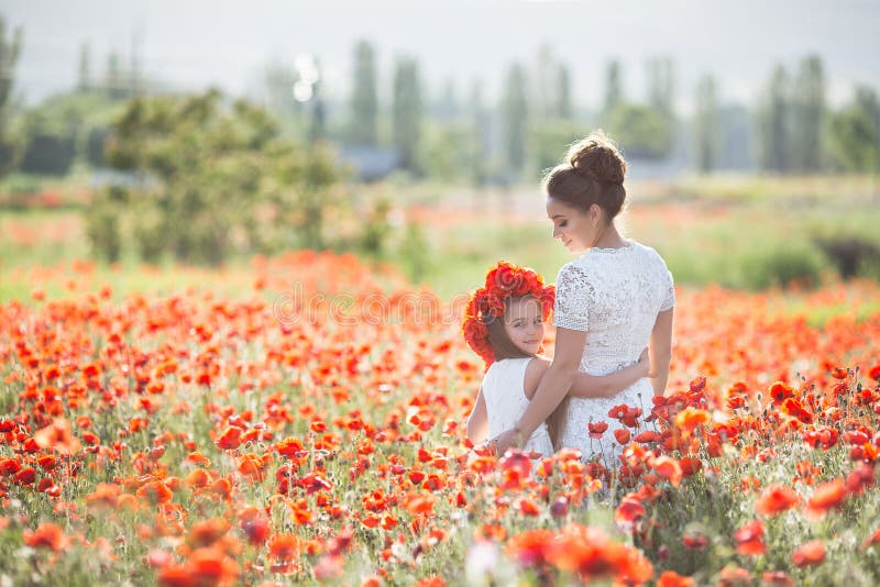 Mãe bonita e sua filha que jogam no campo de flor da mola imagem de stock royalty free Mãe bonita e sua filha que jogam no campo de flor da mola imagem de stock royalty free