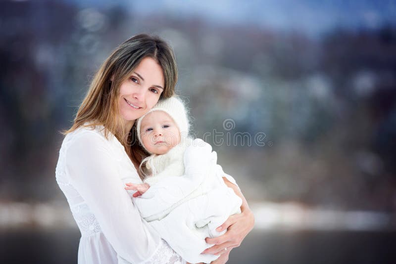 Mãe bonita no vestido branco e no bebê bonito no feito malha imagens de stock royalty free Mãe bonita no vestido branco e no bebê bonito no feito malha imagens de stock royalty free