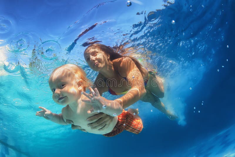 Mãe com a criança que nada debaixo d'água na associação foto de stock Mãe com a criança que nada debaixo d'água na associação foto de stock
