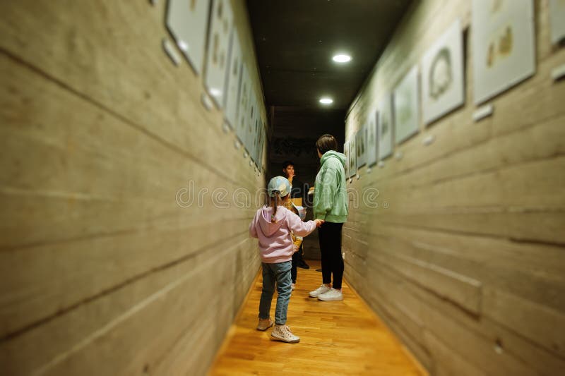 Mãe com filhos a explorar exposições em salas de museu imagens de stock