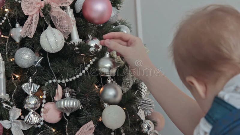 Mãe com o rapaz pequeno que decora a árvore de Natal