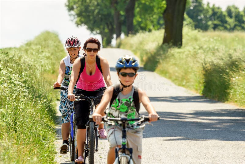 Mãe com os dois filhos na viagem da bicicleta imagens de stock Mãe com os dois filhos na viagem da bicicleta imagens de stock