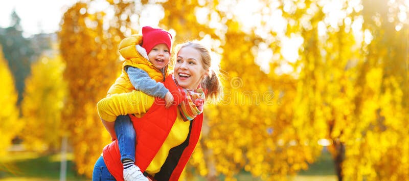 A mãe da família e o filho felizes do bebê no outono andam