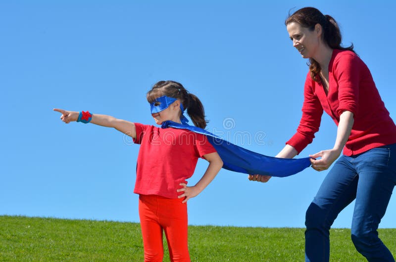 A mãe do super-herói mostra a sua filha como ser um super-herói imagem de stock