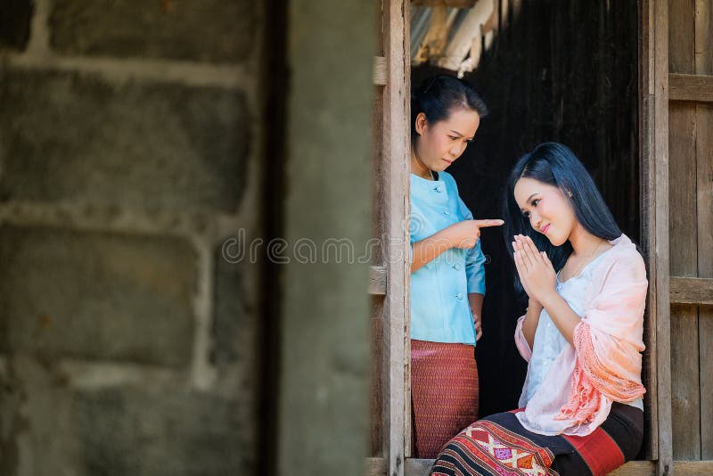 A mãe e duas filhas em um vestido tailandês antigo estão discutindo a filha da janela de madeira imagens de stock royalty free A mãe e duas filhas em um vestido tailandês antigo estão discutindo a filha da janela de madeira imagens de stock royalty free
