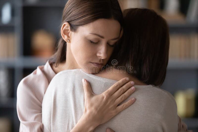 Mãe e filha adultas tristes abraçam-se depois da luta