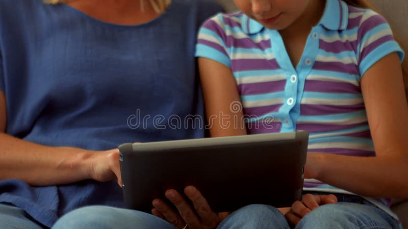 Mãe e filha que usa o PC da tabuleta vídeos de arquivo