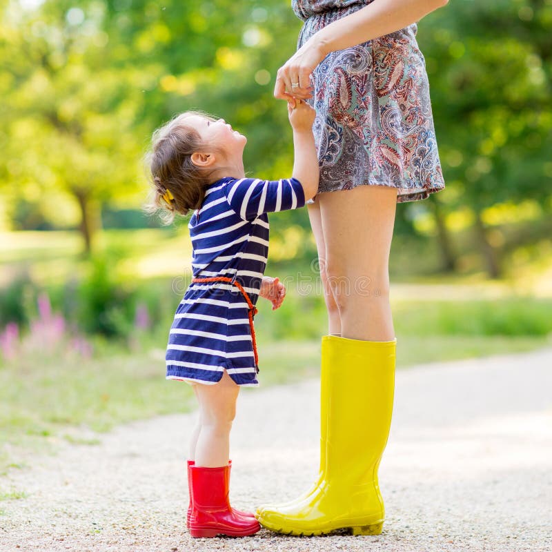 Mãe e menina nas botas de borracha que têm o divertimento imagens de stock royalty free Mãe e menina nas botas de borracha que têm o divertimento imagens de stock royalty free