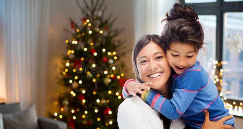 Mãe feliz que abraça sua filha no Natal imagens de stock Mãe feliz que abraça sua filha no Natal imagens de stock