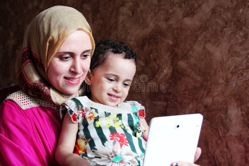 Mãe muçulmana árabe feliz com seu bebê que toma o selfie fotografia de stock Mãe muçulmana árabe feliz com seu bebê que toma o selfie fotografia de stock
