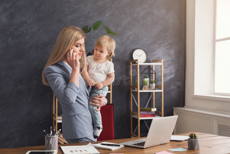 Mãe nova que guarda o bebê ao falar no telefone imagem de stock Mãe nova que guarda o bebê ao falar no telefone imagem de stock