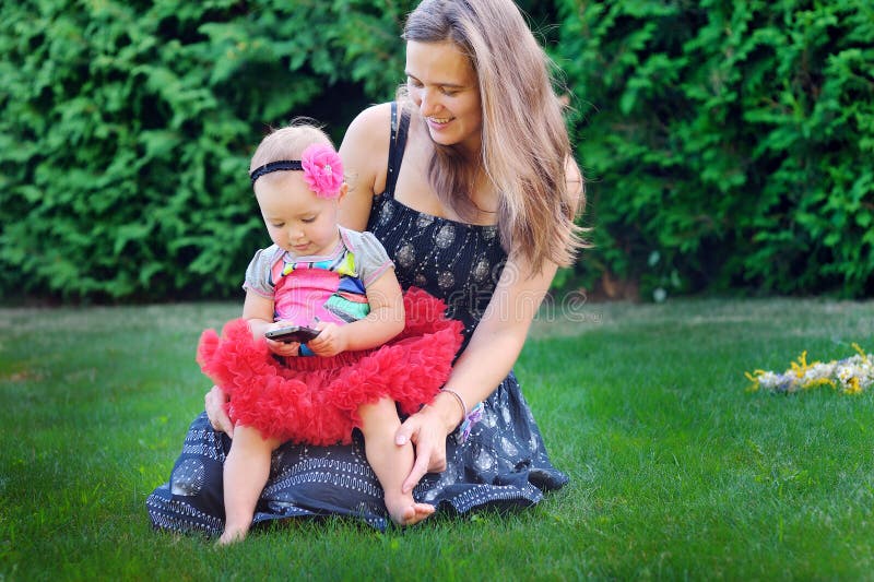 Mãe nova que joga com sua filha em um prado imagens de stock Mãe nova que joga com sua filha em um prado imagens de stock