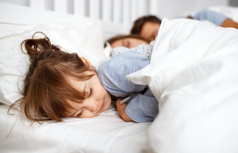 Mãe, pai feliz e criança da família dormindo na cama foto de stock Mãe, pai feliz e criança da família dormindo na cama foto de stock
