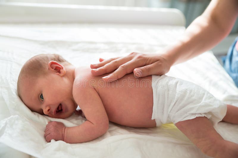 Mãe que Patting na parte traseira do ` s do bebê imagens de stock Mãe que Patting na parte traseira do ` s do bebê imagens de stock