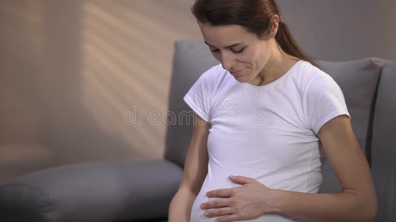 M?e substituto que sorri, beb? do sentimento que move-se na barriga, emo??es positivas fotografia de stock M?e substituto que sorri, beb? do sentimento que move-se na barriga, emo??es positivas fotografia de stock