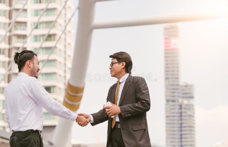 Mão amiga Aperto de mão de dois homens de negócio que fecham um blackground da cidade do negócio foto de stock Mão amiga Aperto de mão de dois homens de negócio que fecham um blackground da cidade do negócio foto de stock