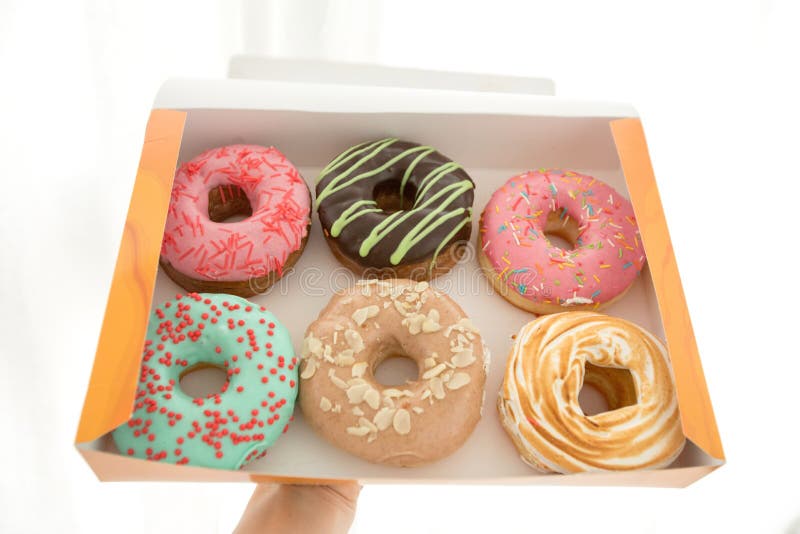 Mão a segurar uma caixa de donuts fotos de stock royalty free