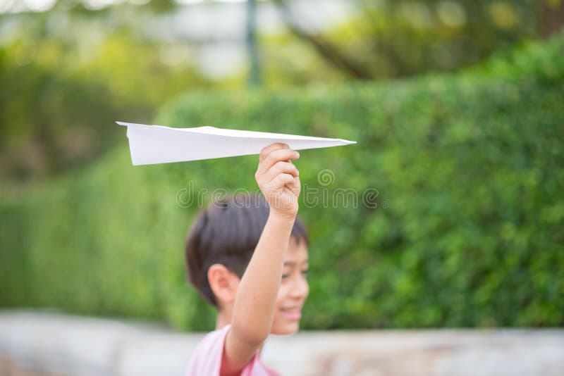 A mão da criança que toma jogando o papel plano o parque imagens de stock royalty free A mão da criança que toma jogando o papel plano o parque imagens de stock royalty free