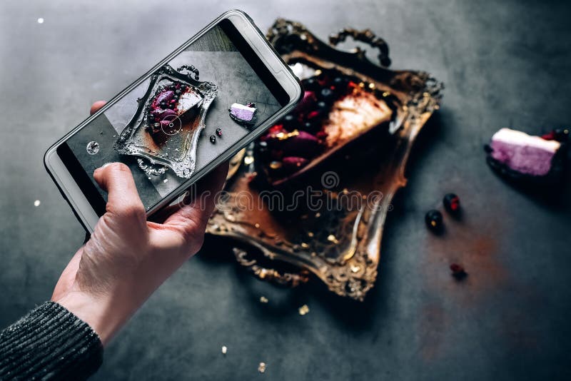 A mão da menina dispara na sobremesa do alimento no telefone o bolo do pudim do souffle do chocolate encheu-se com as bagas fresc imagem de stock royalty free A mão da menina dispara na sobremesa do alimento no telefone o bolo do pudim do souffle do chocolate encheu-se com as bagas fresc imagem de stock royalty free