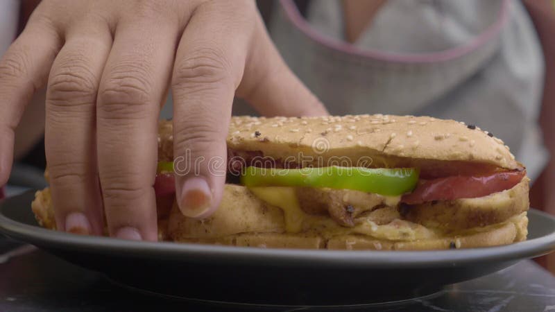 A mão da mulher escolhe um sanduíche de frango vídeos de arquivo