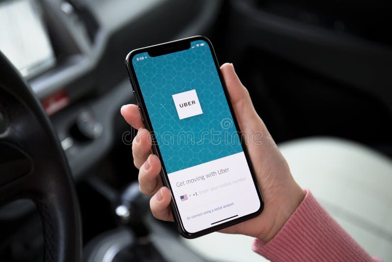 Mão da mulher que guarda o iPhone X com táxi Uber da aplicação imagem de stock Mão da mulher que guarda o iPhone X com táxi Uber da aplicação imagem de stock