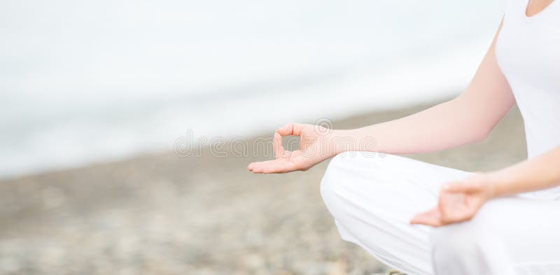 Mão da mulher que medita em uma pose da ioga na praia imagens de stock Mão da mulher que medita em uma pose da ioga na praia imagens de stock