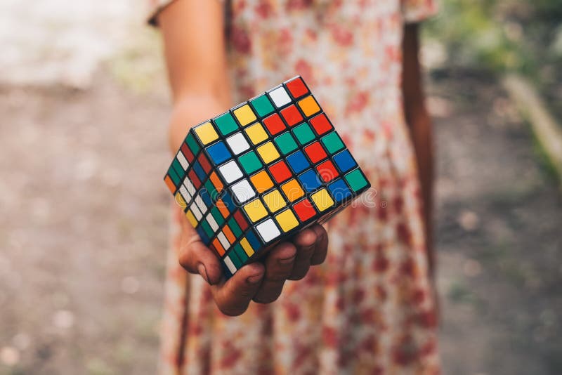 Mão de uma moça que guarda o cubo foto de stock Mão de uma moça que guarda o cubo foto de stock