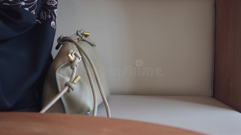 Mão de uma mulher pegue uma bolsa de um sofá vídeos de arquivo