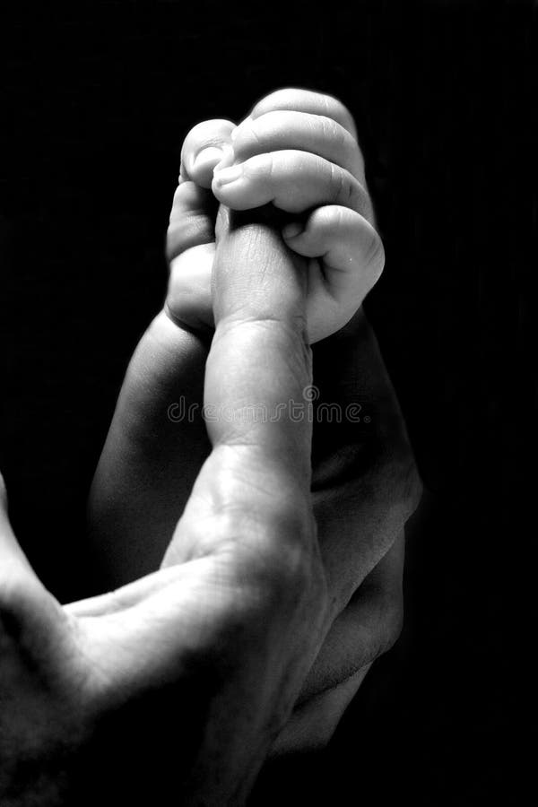 Mão do bebê que prende um dedo